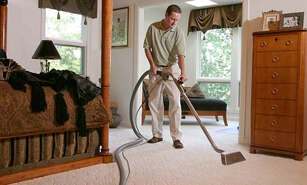 Technician cleaning bedroom carpet in a residential home